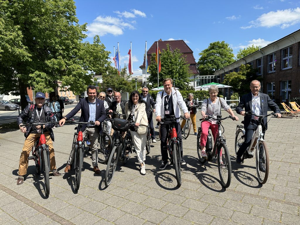 Gruppenbild von Vertreter*innen der Städte Kamen und Montreuil-Juigné bei einer Fahrradtour im Rahmen der gemeinsamen Teilnahme an der TANDEM-Edition von STADTRADELN anlässlich des 55. Jubiläums ihrer Partnerschaft. Benoit Cochet, Bürgermeister von Montreuil Juigné (2. von links), Elke Kappen, Bürgermeisterin von Kamen (3. von links), und Brigitte Dubois, Vorsitzende des Comité de Jumelage (5. von links).